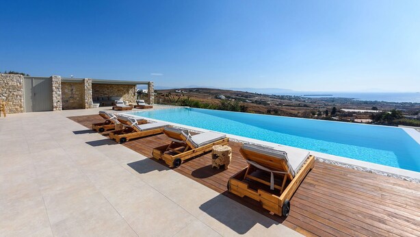 Area piscina con sedie a sdraio e vista sul paesaggio.