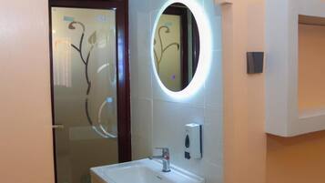 Ducha, artículos de tocador gratuitos, pantuflas, toallas