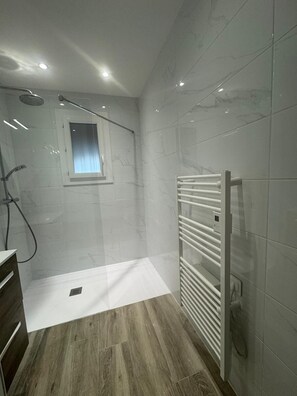 Een douche, een haardroger, handdoeken, toiletpapier