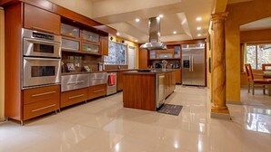 Une cuisine moderne dotée d’appareils électroménagers en acier inoxydable, de meubles de rangement en bois et d’un îlot central.