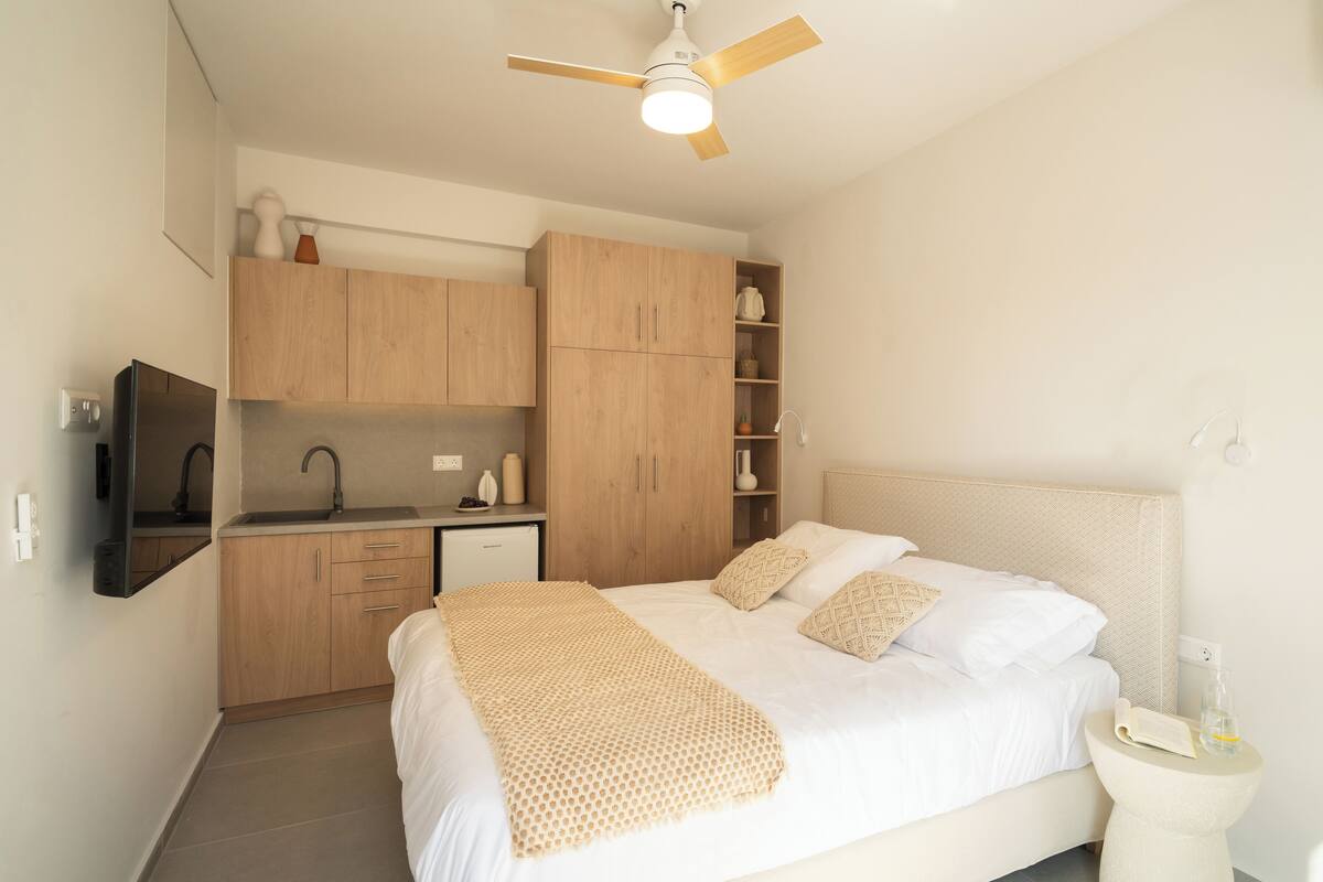 A bedroom with a bed, bedside table, and a ceiling fan.