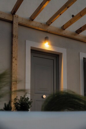 Una estructura de madera con una puerta y una lámpara colgante arriba.