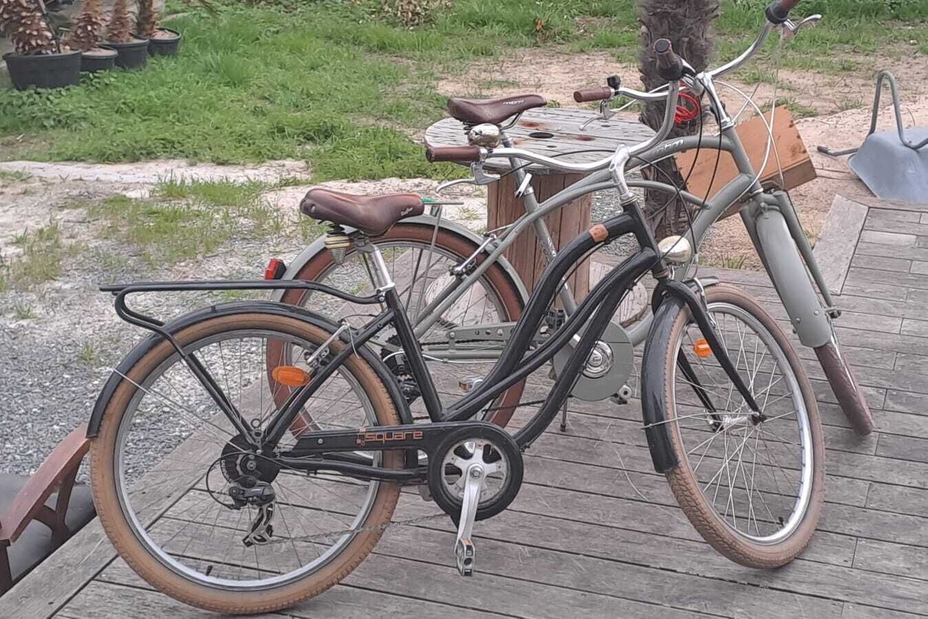 Una bicicleta estática con asiento marrón y estructura negra, estacionada sobre una cubierta de madera.