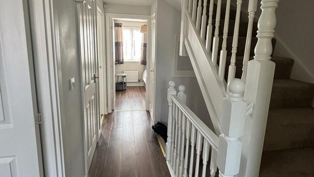 A hallway with a white staircase leading to a landing. - Trowbridge House, Long Stay Disc, Parking, Wifi (Swindon)