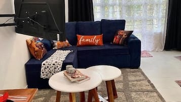 Departamento, vista al jardín | Área de sala de estar | Smart TV de 24 pulgadas con canales digitales