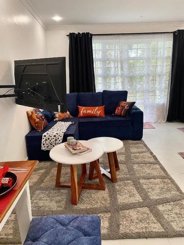 Departamento, vista al jardín | Área de sala de estar | Smart TV de 24 pulgadas con canales digitales 
