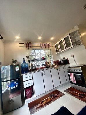 Deluxe Apartment, Garden View | Private kitchen | Fridge, microwave, cookware/dishes/utensils - Lux Suites Kiamboni Apartments (Nakuru)