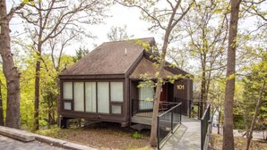 Une cabane dotée d’un balcon, entourée d’arbres, et portant le numéro 101.