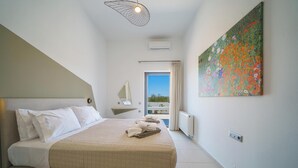 Un dormitorio con cama, un cuadro, una ventana y un balcón.