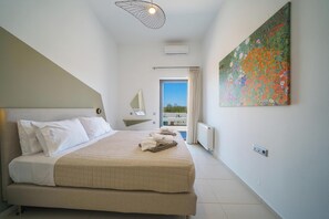 Un dormitorio con cama, un cuadro, una ventana y un balcón.