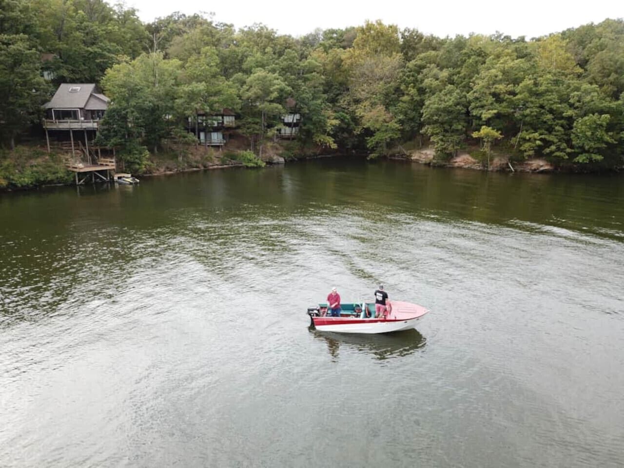 A boat on a calm lake with a forested shore.
