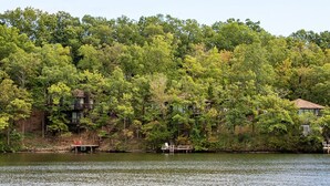 Une propriété située au bord d’un lac, comprenant plusieurs bâtiments et entourée d’une forêt dense.