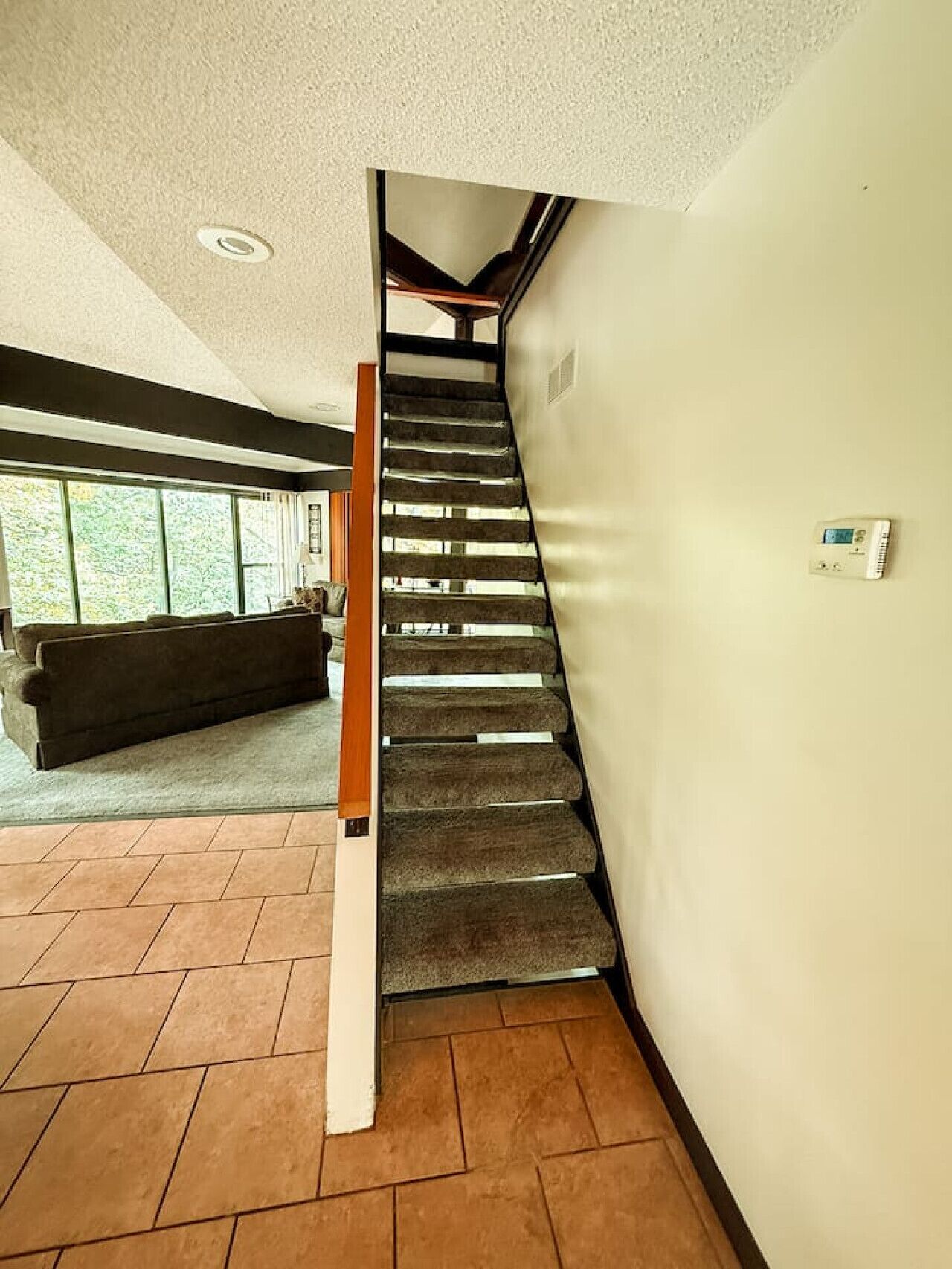A staircase with a wooden handrail leading to a landing.