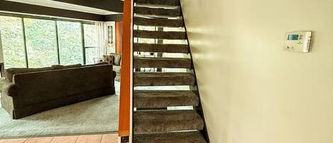 A staircase with a wooden handrail leading to a landing.