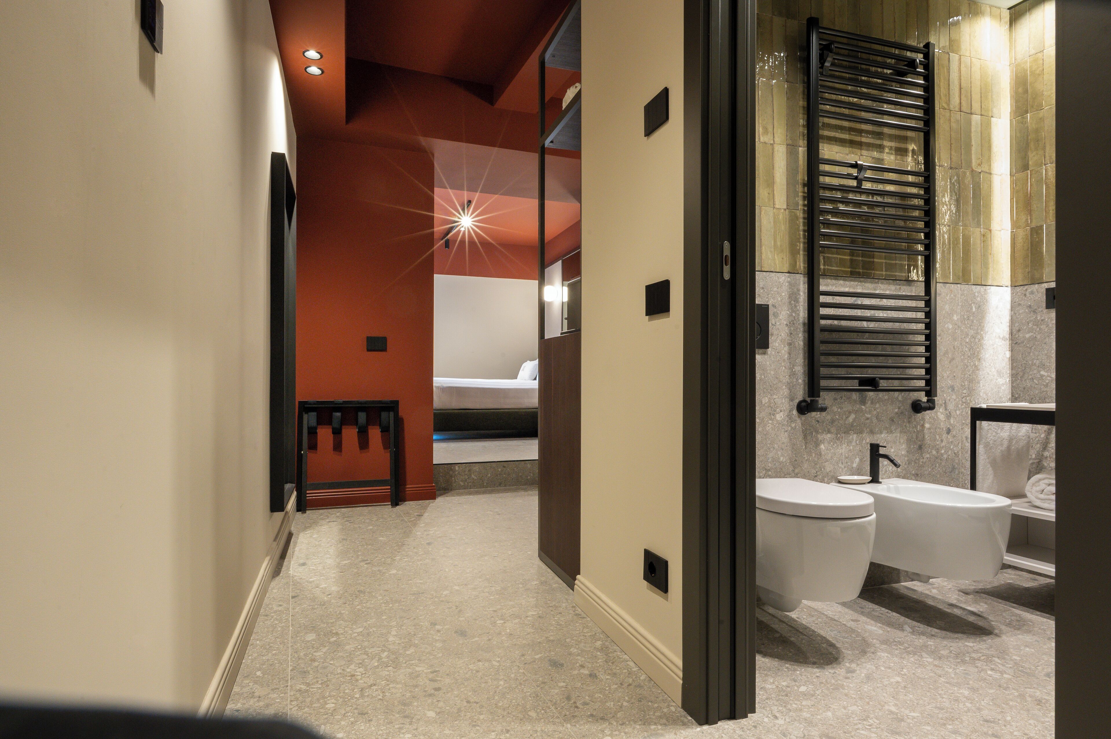 Une salle de bain moderne équipée de toilettes, d’un bidet et d’un porte-serviettes.