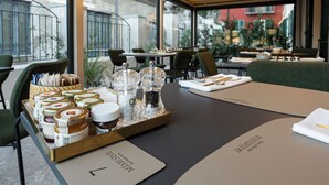 Comedor con una mesa lista para dos, destacando una bandeja con condimentos y un menú.