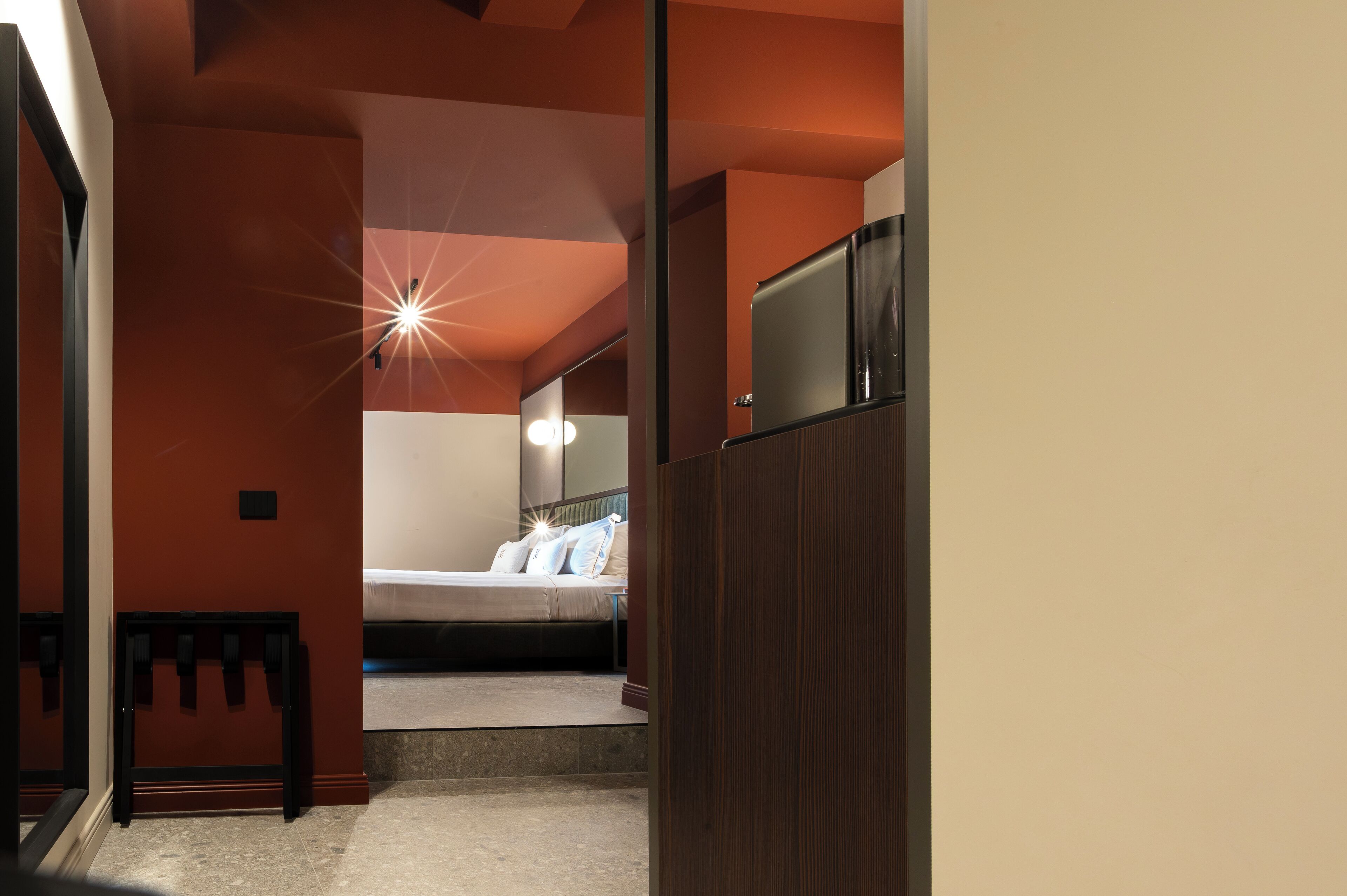 Une chambre d’hôtel avec un lit, une table de chevet et une armoire.