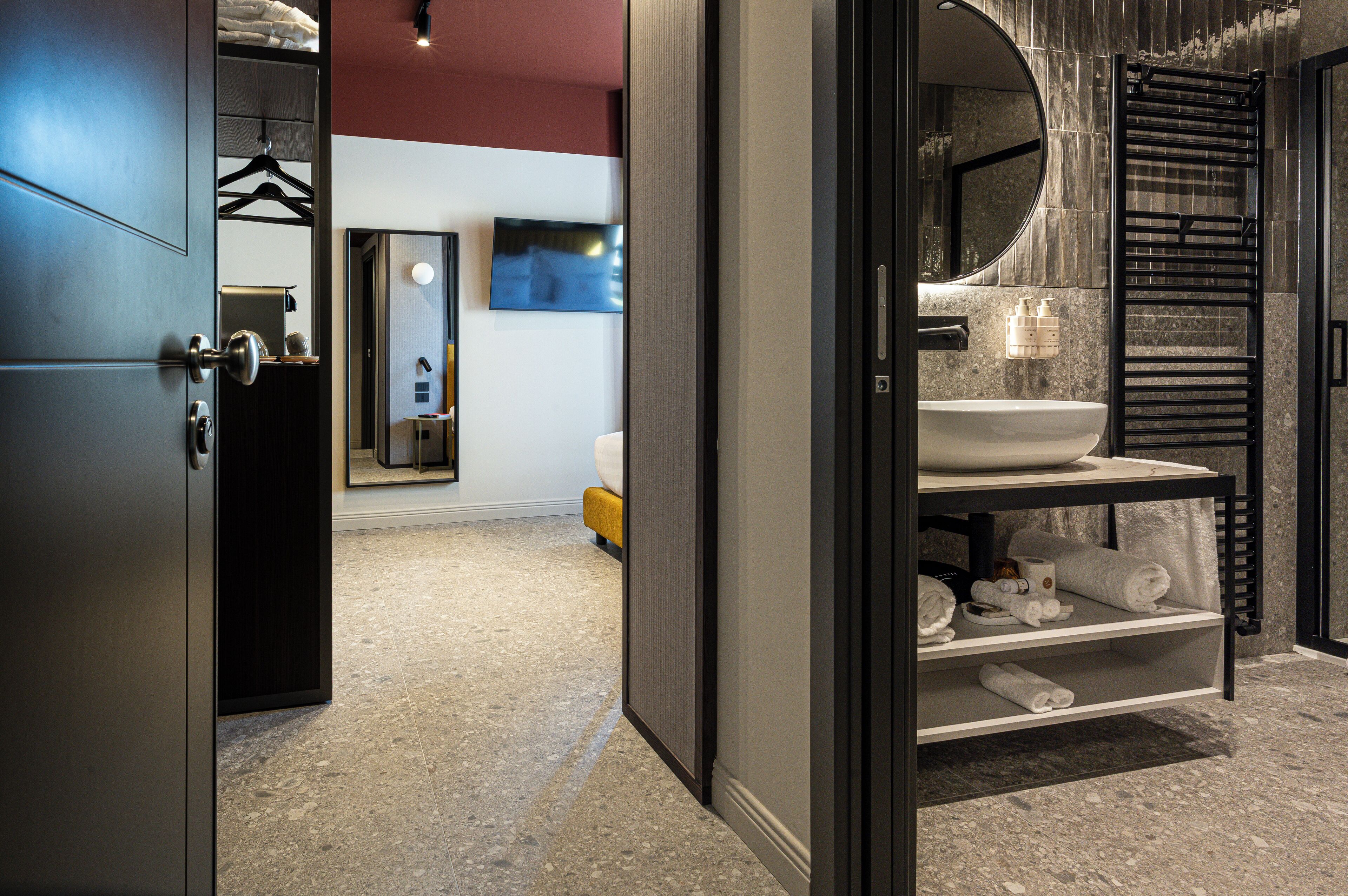 A modern bathroom with a large mirror, a sink, and a towel rack.
