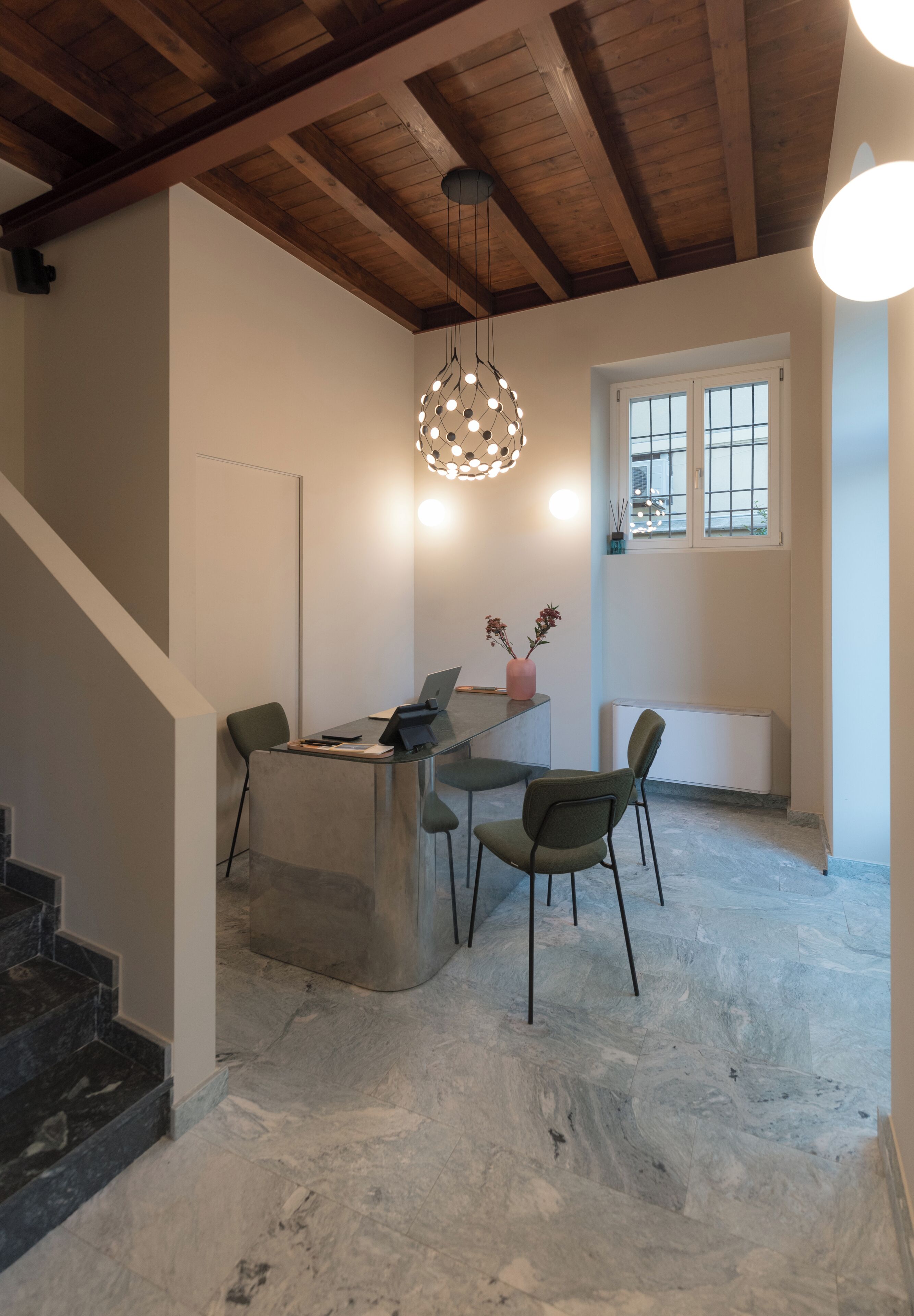 Een modern interieur met een houten plafond, een bureau met stoelen, een hanglamp en een raam met uitzicht.