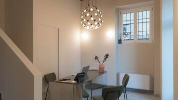 Een modern interieur met een houten plafond, een bureau met stoelen, een hanglamp en een raam met uitzicht.