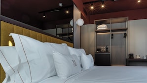 Una habitación de hotel moderna con una cama grande, un armario y un espejo.