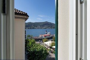 Une vue sur un lac, avec un bateau, des bâtiments et de la végétation.