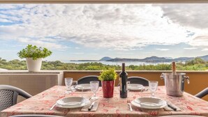 A table set for dining with a view of a lake and mountains. - SMERALDA Blue Sky (Portisco)