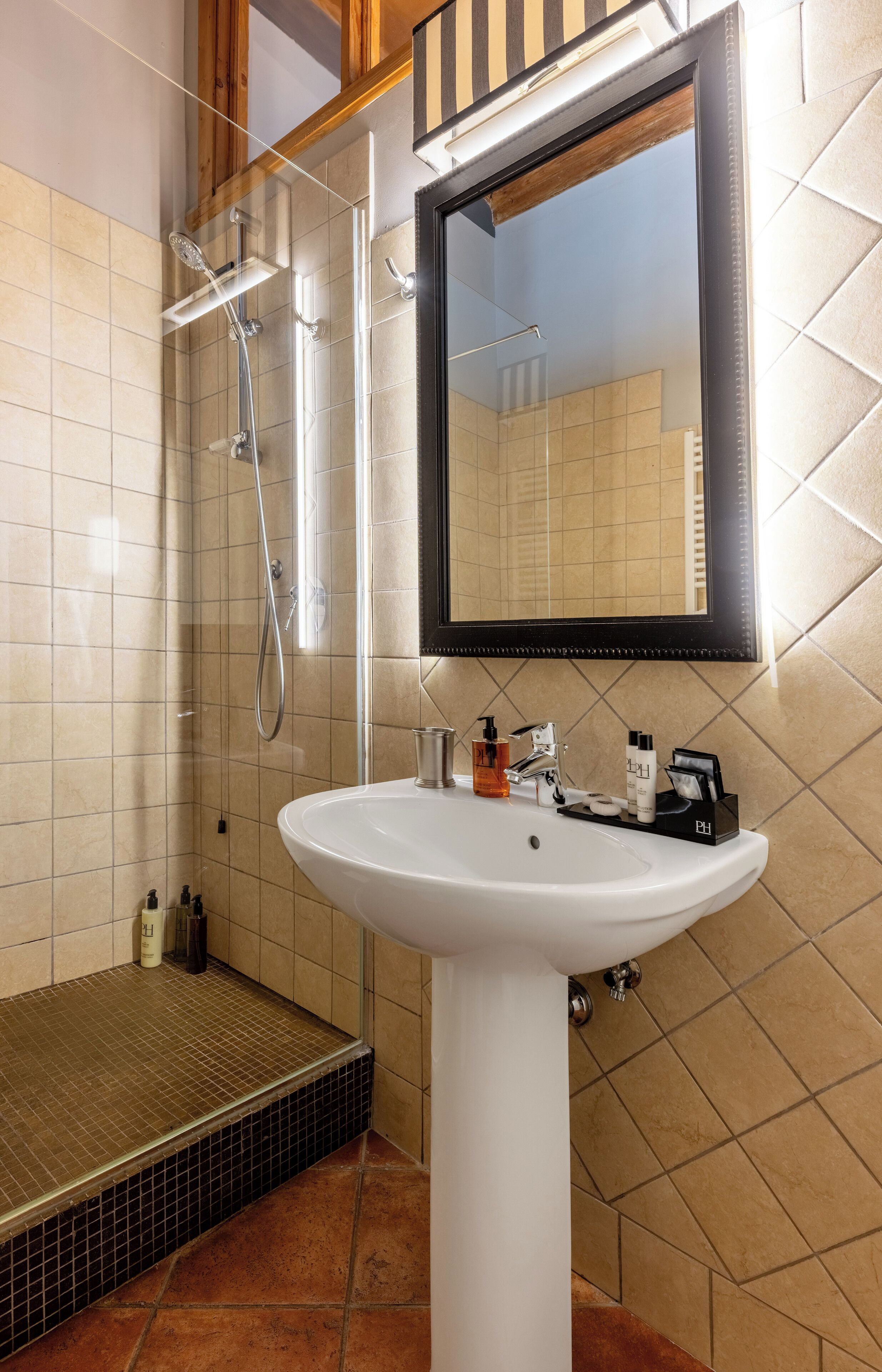 A bathroom with a white sink, a mirror, and a shower.