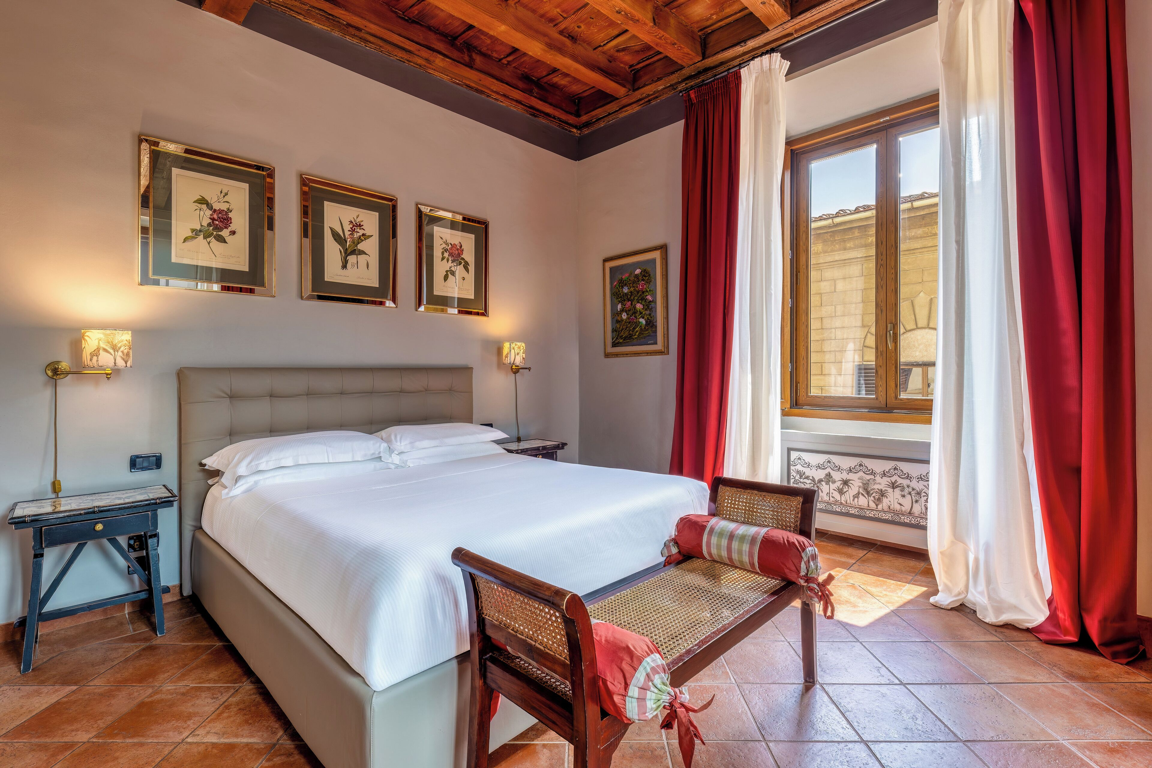 Une chambre à coucher avec un lit, une table de chevet, une chaise et une fenêtre avec des rideaux.