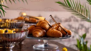 A breakfast buffet with croissants, fruits, and a decorative glass bowl on a wooden table. - Antica Dimora De Benci (Florence)