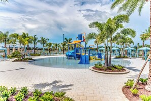 A playground with slides and climbing structures, surrounded by palm trees and lounge chairs. - 1808 Sandy Park Trail (Kissimmee)