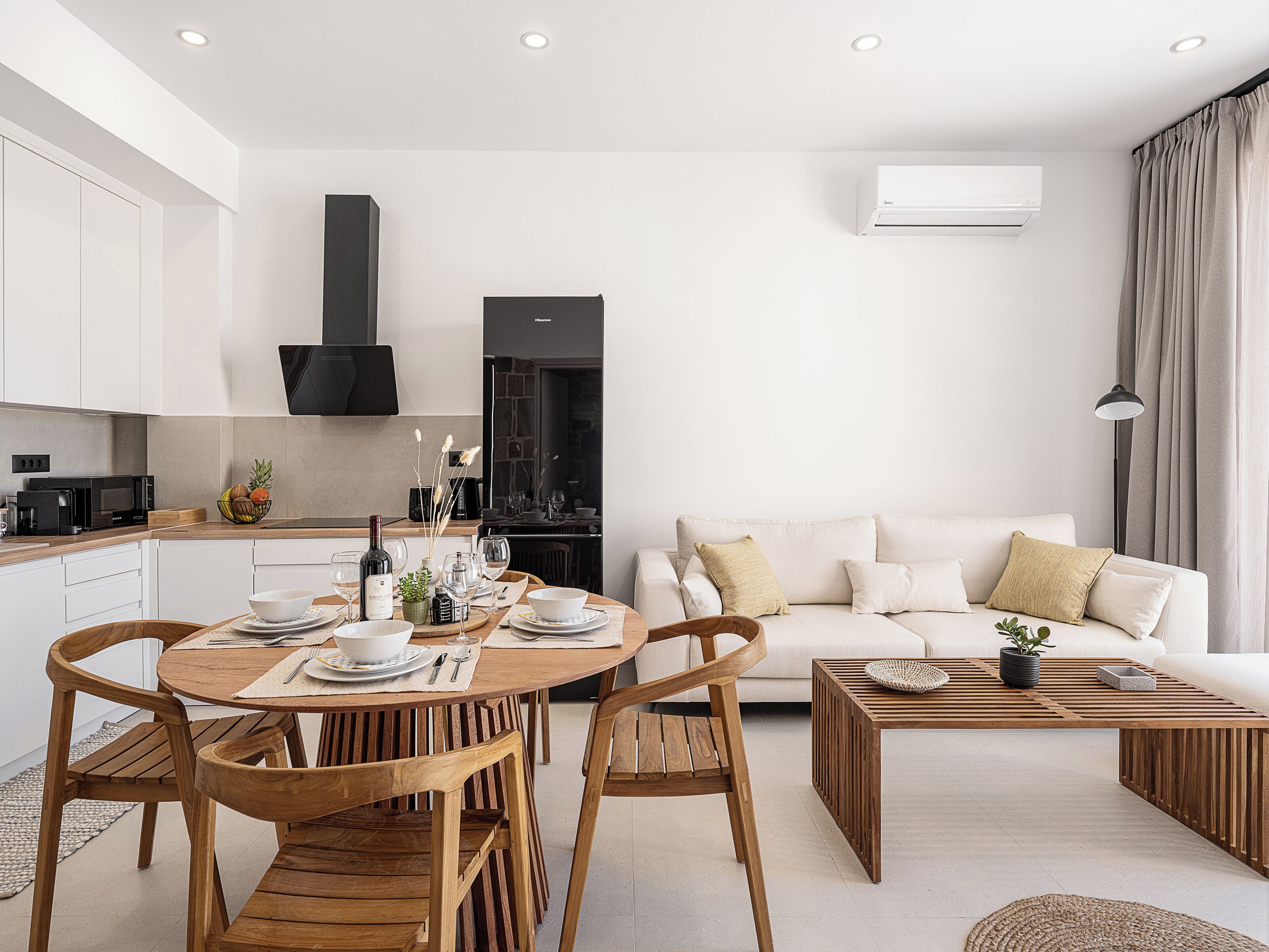 Un espace de vie moderne comprenant un coin repas, une cuisine et un coin salon.