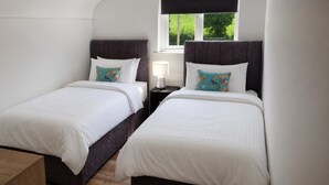 A twin room with two beds, a nightstand with a lamp, and a window with a view of greenery. - 2 Bed Cottage-sleeps 4-private Garden-parking (Omagh)