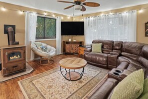 A cozy living room with a fireplace, leather sofa, and a round coffee table.