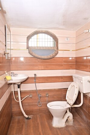 Une salle de bain équipée de toilettes, d’un lavabo et d’une douche.