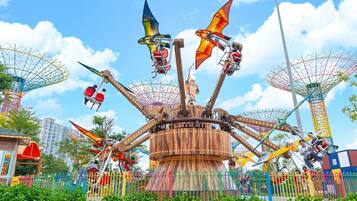 A carousel with multiple seats and a central wooden structure.