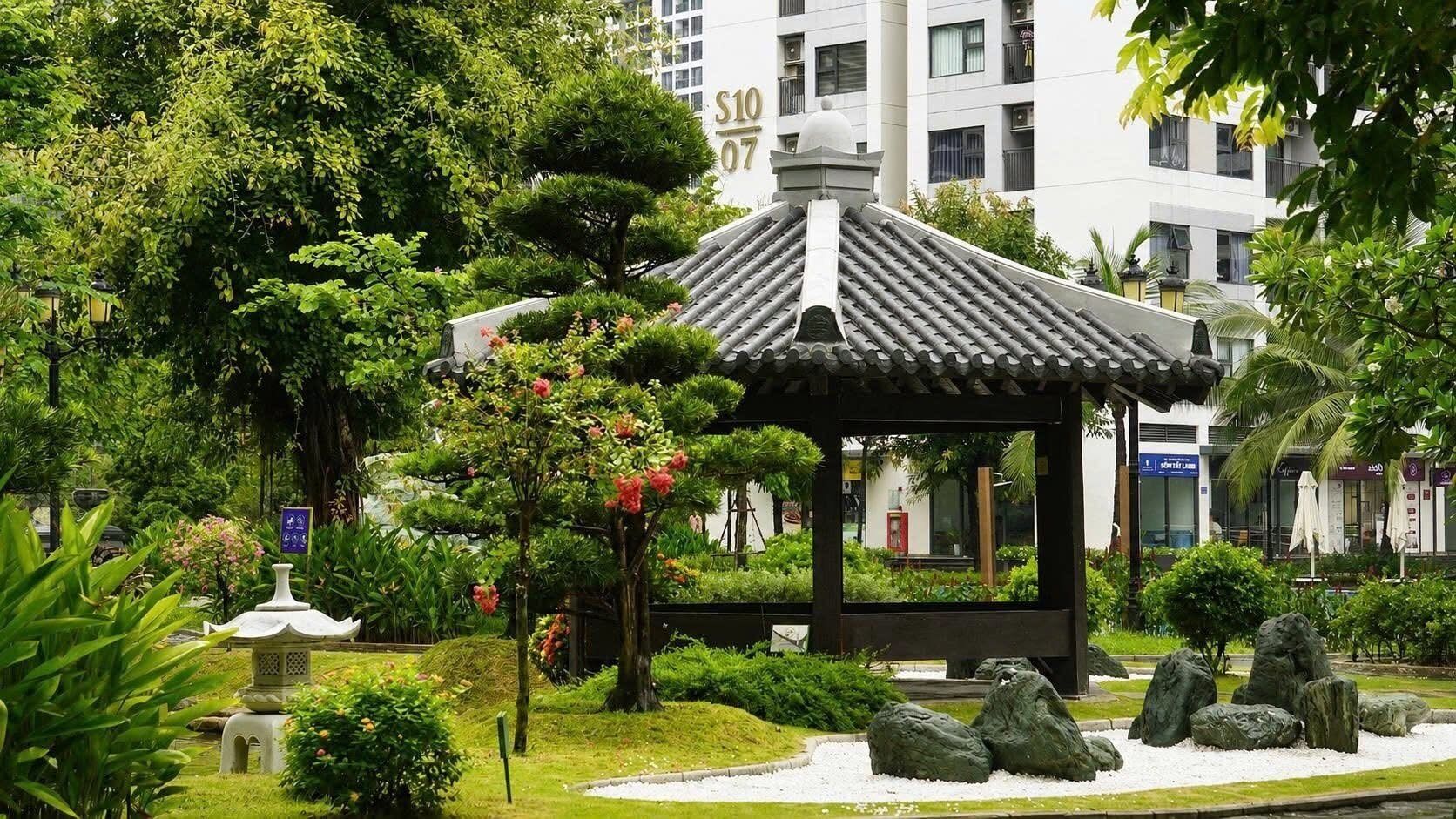 A traditional pavilion surrounded by lush greenery and a building with a sign '310 307'.