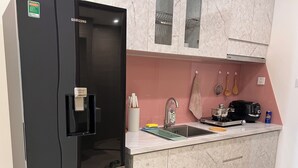 Eine moderne Küche mit einem schwarzen Kühlschrank, einer Spüle und einem Herd.