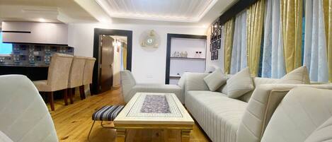 Una sala de estar moderna con un conjunto de sofá, una mesa de centro y un comedor con sillas.