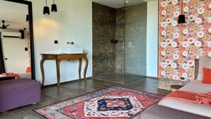 Un baño moderno con cabina de ducha de vidrio, tocador de madera y un espejo grande.