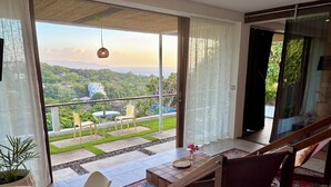 Un balcón con vistas a un paisaje exuberante y un paisaje urbano lejano.