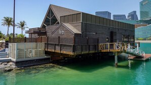 Ein Gebäude am Wasser mit Holzfassade und geneigtem Dach, das ein auffälliges 'fin'-Logo zeigt.