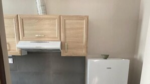 Cocina compacta con estufa, horno, refrigerador y lavadora.