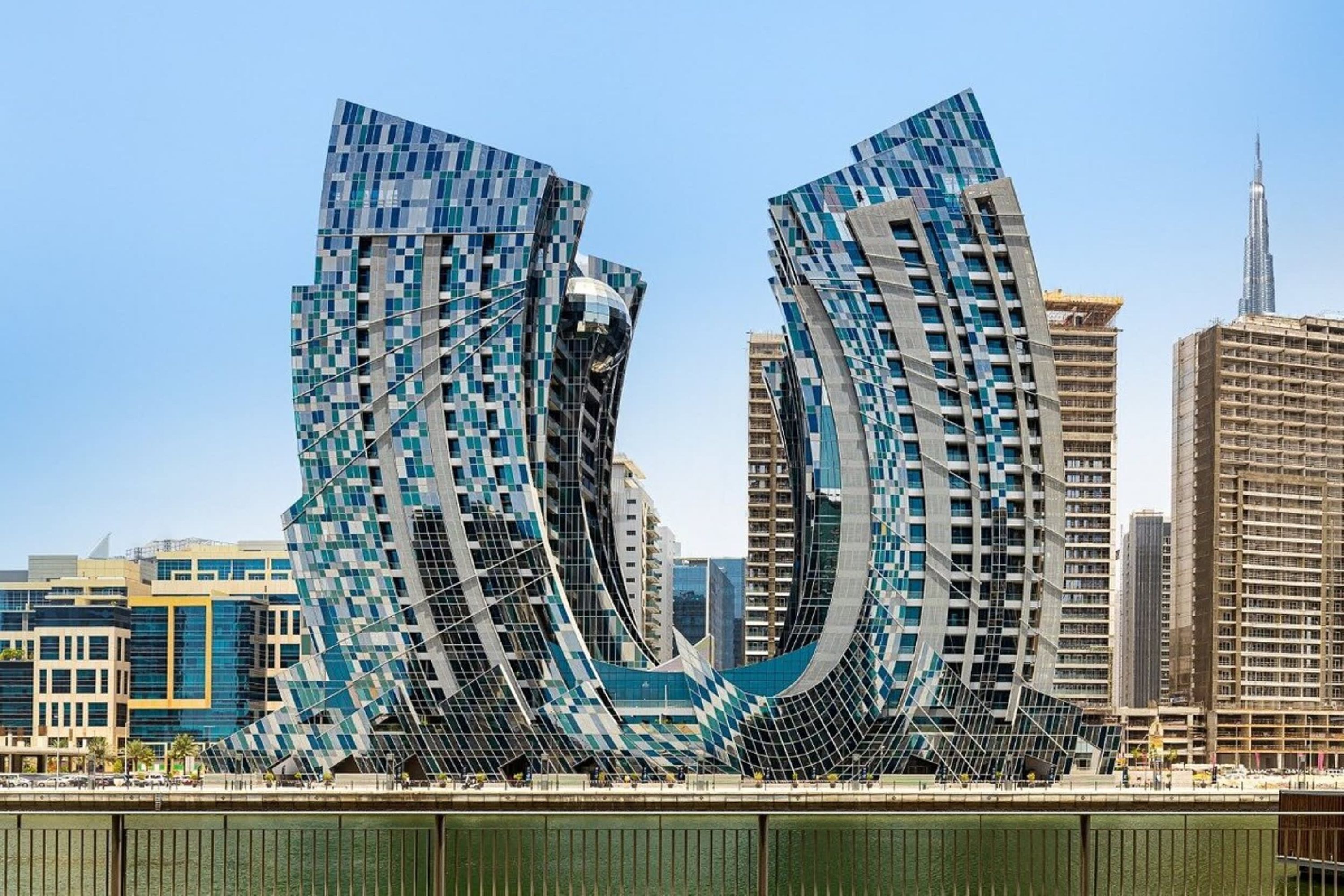 Ein modernes Gebäude mit einem markanten, geschwungenen Design, umgeben von weiteren Hochhäusern.