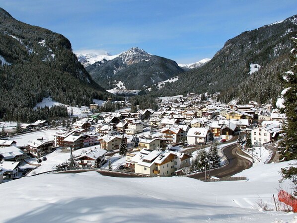 A snow-covered mountain town with buildings and a winding road.