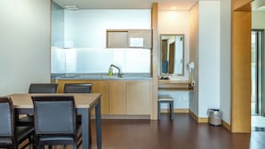 Une cuisine moderne équipée d’une cuisinière intégrée, d’un évier et d’un coin repas avec une table et des chaises.