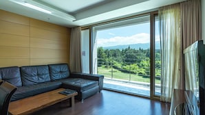 Un salon moderne avec un canapé en cuir, une table basse en bois et un téléviseur à écran plat.