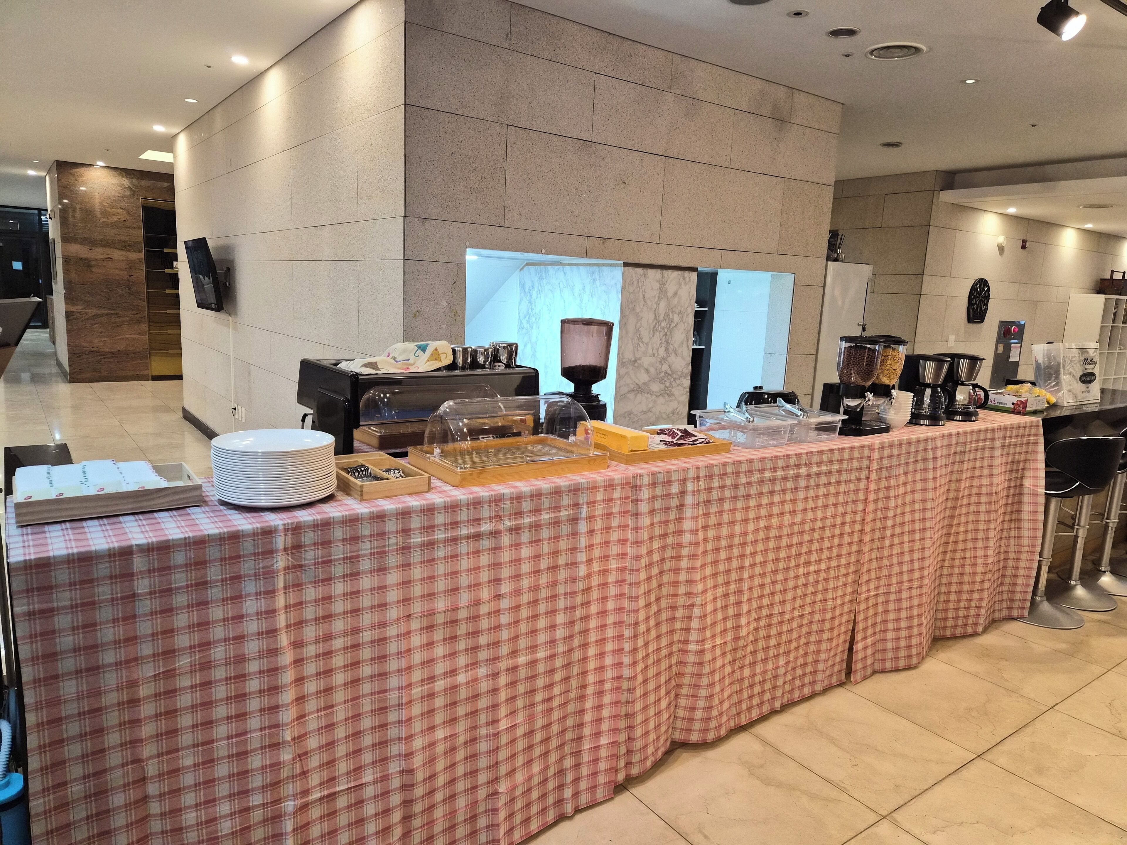A buffet setup with various food dispensers and a check-in counter.