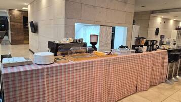 A buffet setup with various food dispensers and a check-in counter.