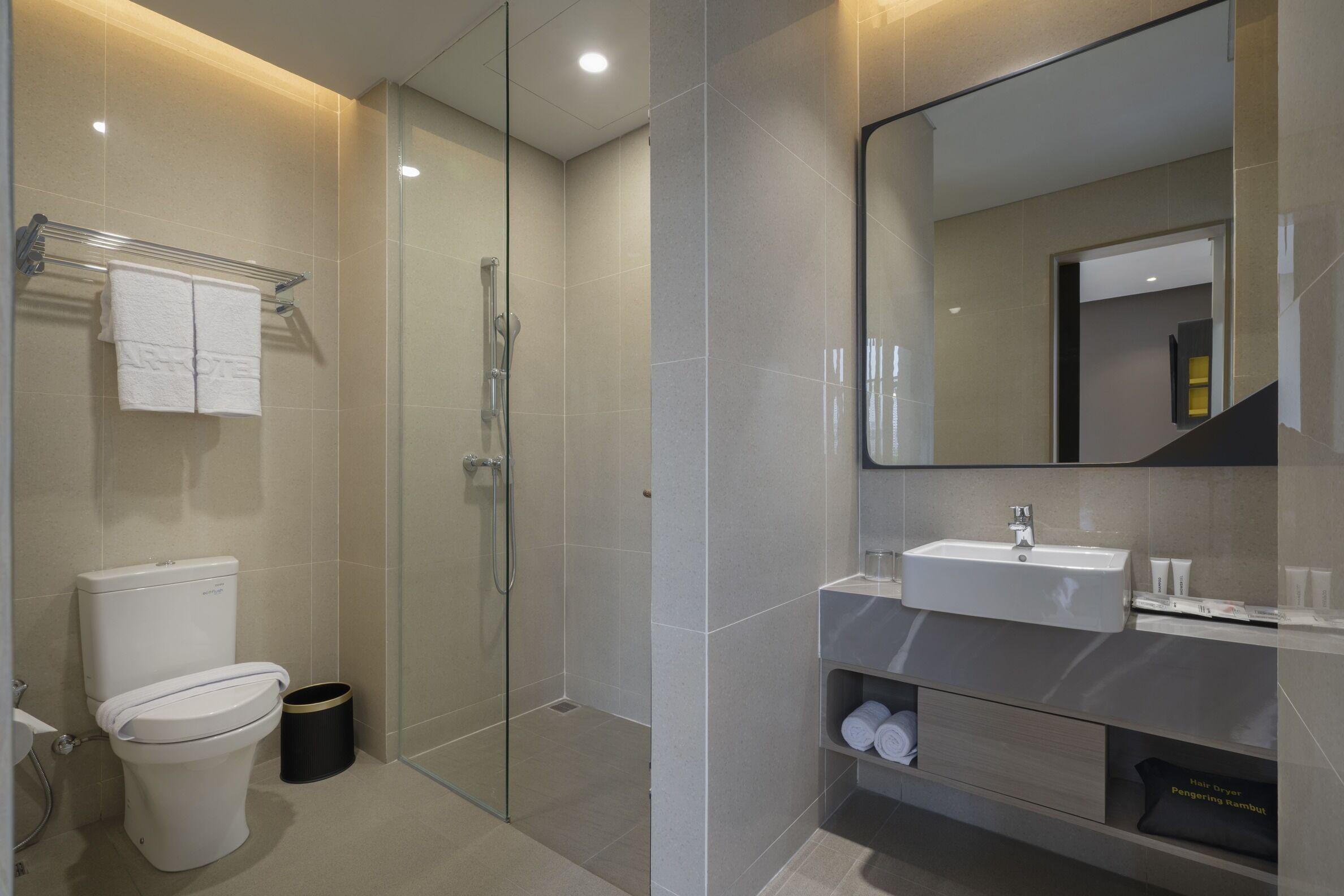 A modern bathroom with a toilet, shower, and sink.